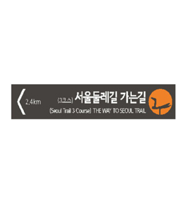 서울둘레길 방향을 안내하는 방향안내판, '서울둘레길 가는길 (Seoul Trail 3 Course) THE WAY TO SEOUL TRAIL'과 왼쪽 방향 화살표가 표시됨