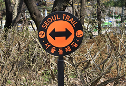 서울둘레길 방향을 가리키는 지주형 안내판, 좌우 방향 화살표와 'Seoul Trail 서울둘레길'이라는 글씨가 표시됨